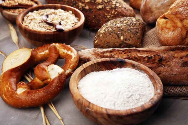 Assortimento di pane e panini al forno e pane tagliato su ta — Foto Stock