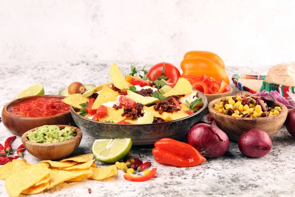 Mexican nacho chips garnished with ground beef, guacamole, melte — Stockfoto