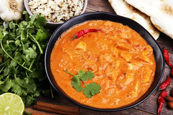 Chicken tikka masala spicy curry meat food in pot with rice and