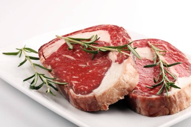 Çiğ et, pirzola, baharat ve et çatalı.