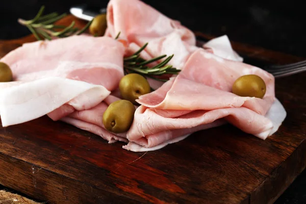Sliced ham on wooden background. Fresh prosciutto. Pork ham slic
