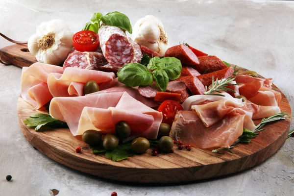Bandeja de comida con delicioso salami, trozos de jamón crudo en rodajas — Foto de Stock
