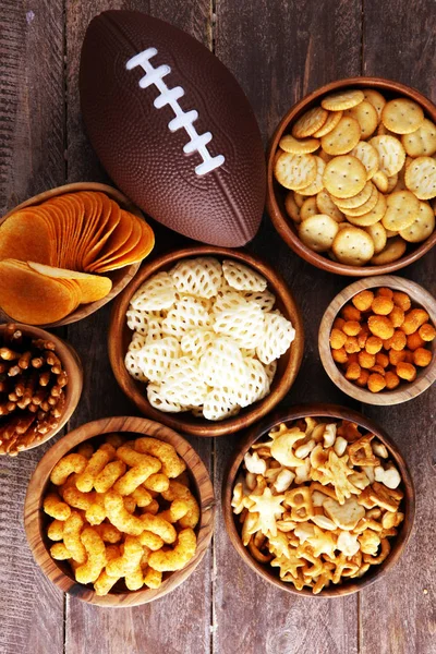 Chips, salty snacks, football on a table. Great for Bowl Game sn — Stock Photo, Image