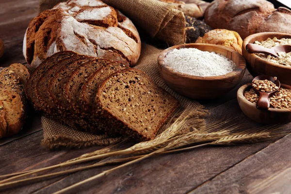 Assortment of baked bread and bread rolls and cutted bread on ta — Stock Photo, Image