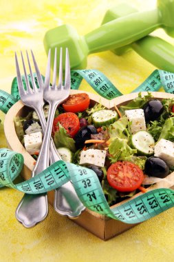 Dambılı ahşap kalp şeklindeki bardakta hakiki taze salata.