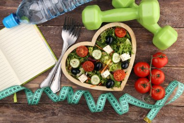 Dambılı ahşap kalp şeklindeki bardakta hakiki taze salata.