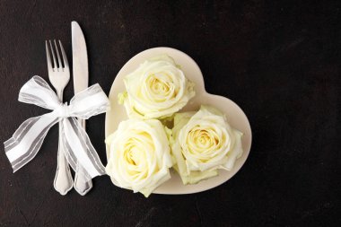 Beyaz tepside beyaz gül. Sevgililer Günü 'nde kadınlar için yemek.