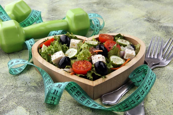 Authentic fresh salad in a wooden heart shaped cup with dumbbell — Stock Photo, Image