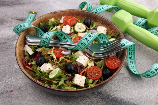 Authentieke verse salade in een stenen beker met halters excercise eq — Stockfoto