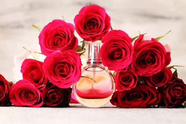 Butelka perfum z kwiatami na rustykalnym tle. Zapach aromatu — Zdjęcie stockowe