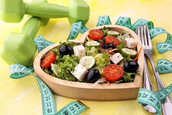 Authentic fresh salad in a wooden heart shaped cup with dumbbell — Stock Photo, Image