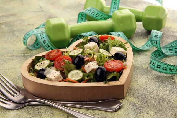Authentic fresh salad in a wooden heart shaped cup with dumbbell — Stock Photo, Image