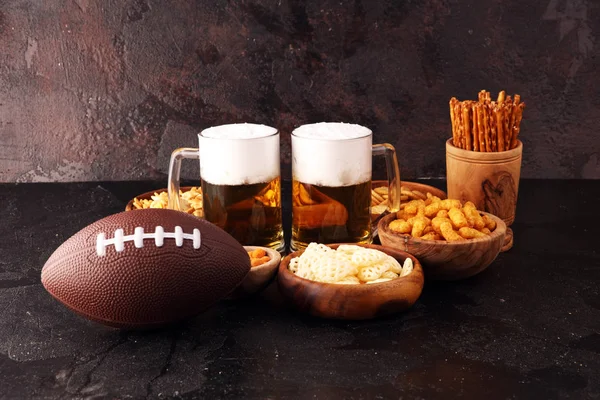 Chips, zoute snacks, voetbal en bier op tafel. Geweldig voor Bow — Stockfoto