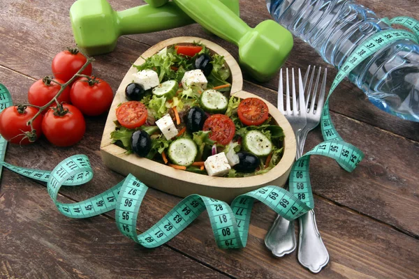 Authentieke verse salade in een houten hartvormige beker met halter — Stockfoto