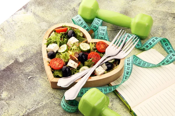 Auténtica ensalada fresca en una taza en forma de corazón de madera con campana de dumbbell. —  Fotos de Stock