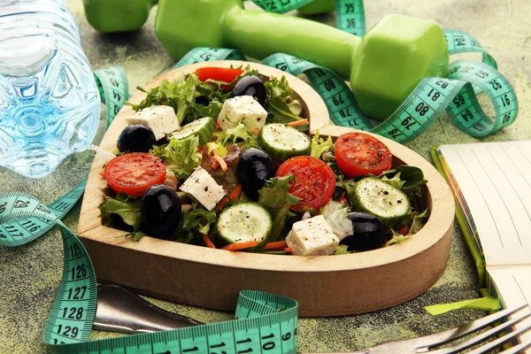 Authentic fresh salad in a wooden heart shaped cup with dumbbell — Stock Photo, Image