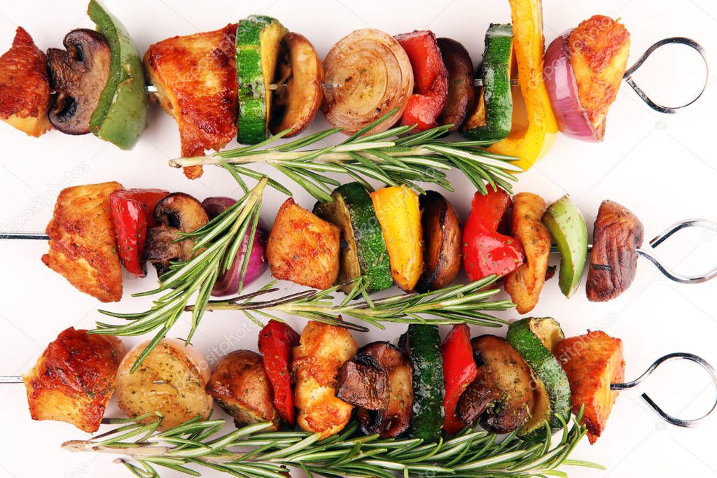 Grilled pork shish or kebab on skewers with vegetables . Food ba