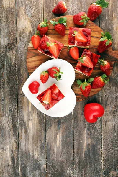 Jordgubbstårta och många färska jordgubbar på rustikt bord — Stockfoto