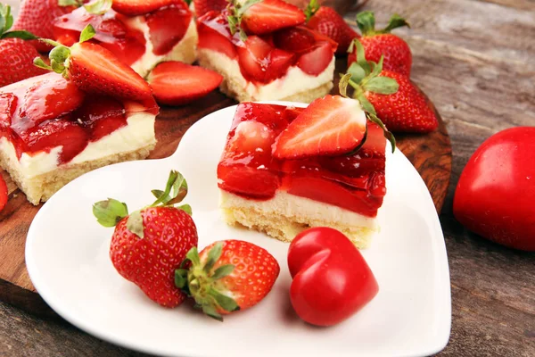 Aardbeientaart en veel verse aardbeien op rustieke tafel — Stockfoto