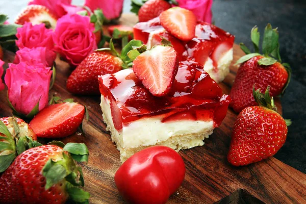 strawberry cake and many fresh strawberries on rustic table with