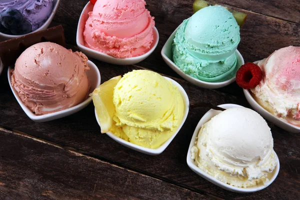 Various of ice cream flavor with fresh blueberry, strawberry, kiwi, lemon, vanilla setup on rustic background . Summer and Sweet ice cream