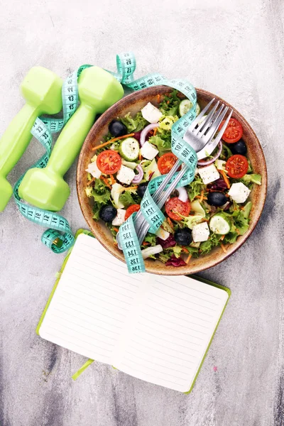真正新鲜的沙拉在一个石头杯子与哑铃锻炼设备 测量带和叉子在桌子上 健康的生活方式 健康的概念 — 图库照片