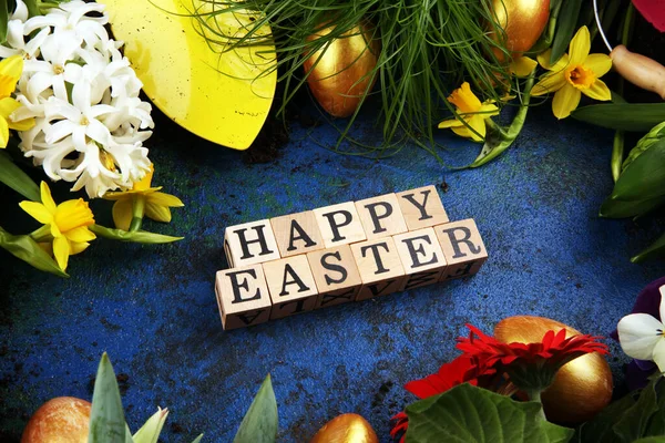 Happy Easter wooden letter. Holiday concept design. Happy Easter flat lay with flower and eggs in beatiful colors.