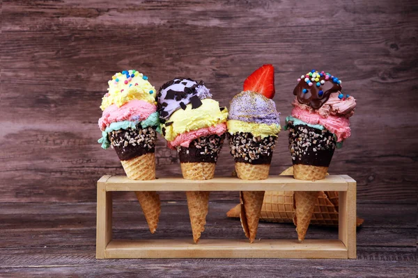 Colorful ice cream cone, rainbow jimmies, chocolate and strawberry toppings floating. Ice cream summer concept with toppings