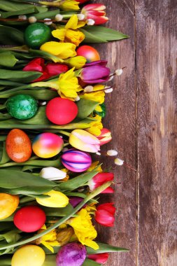 Kırsal arka planda bahar dekorasyonu için çiçek açan nergisler ve paskalya yumurtaları