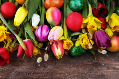 Kırsal arka planda bahar dekorasyonu için çiçek açan nergisler ve paskalya yumurtaları