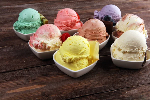 Various of ice cream flavor with fresh blueberry, strawberry, kiwi, lemon, vanilla setup on rustic background . Summer and Sweet ice cream