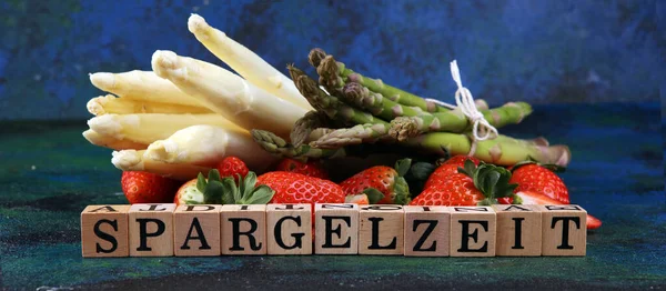 白色和绿色新鲜芦笋与一堆健康的草莓与Spargelzeit木制字母 — 图库照片