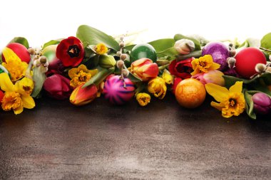 Kırsal arka planda bahar dekorasyonu için çiçek açan nergisler ve paskalya yumurtaları