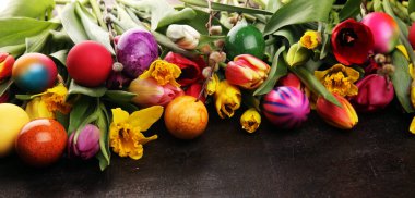 Kırsal arka planda bahar dekorasyonu için çiçek açan nergisler ve paskalya yumurtaları