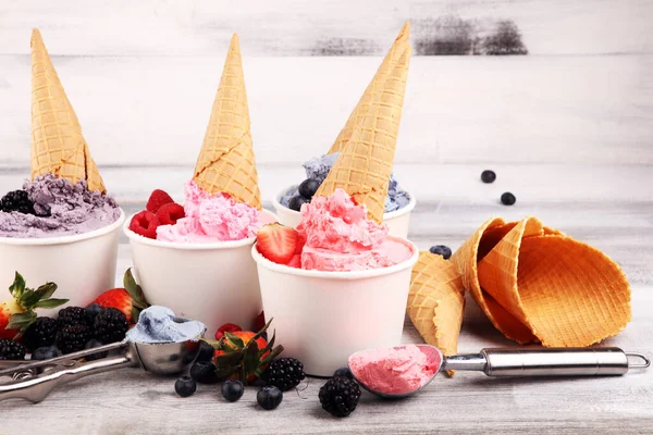 Various of ice cream flavors blueberry, strawberry, blackberry setup on rustic background . Summer and Sweet menu concept. Berries and ice cream