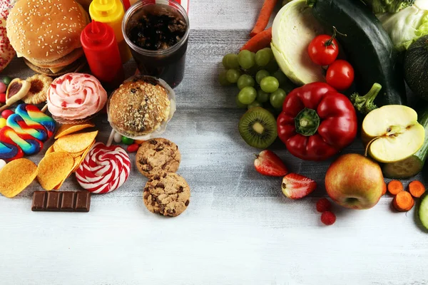 健康或不健康的食物 健康及不健康食物的概念照片 水果和蔬菜对着桌上的甜甜圈 糖果和汉堡包 — 图库照片