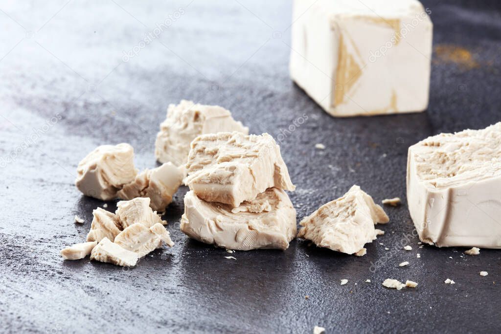 Dry yeast crumbled and yeast block for baking on table