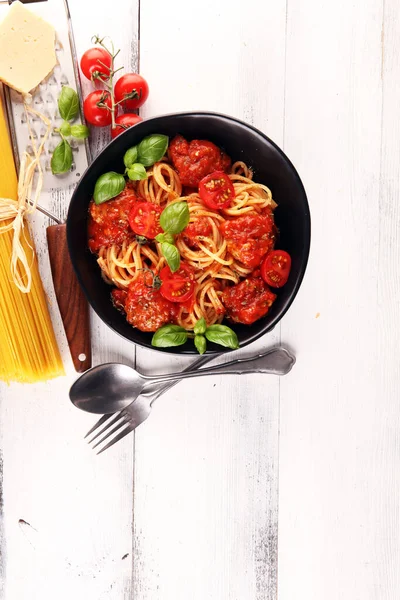 Lezzetli iştah açıcı klasik İtalyan spagettisi domates soslu makarna, peynirli parmesan ve malzemeli fesleğen.