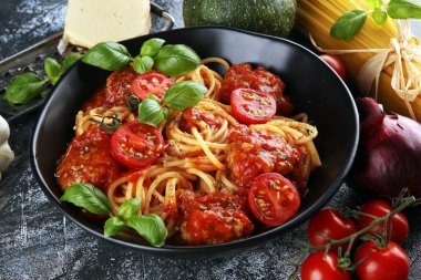 Lezzetli iştah açıcı klasik İtalyan spagettisi domates soslu makarna, peynirli parmesan ve malzemeli fesleğen.