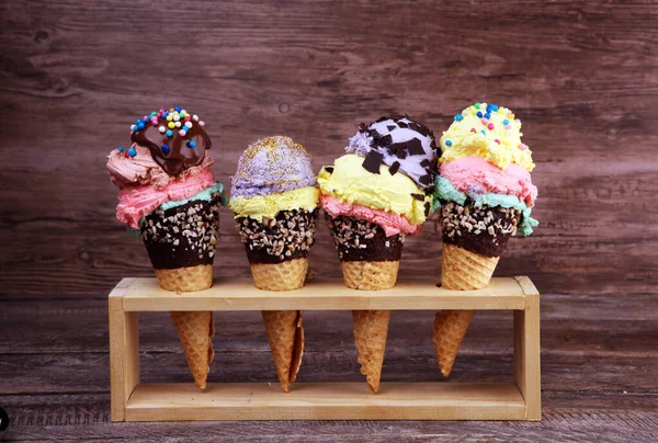 Colorful ice cream cone, rainbow jimmies, chocolate and strawberry toppings floating. Ice cream summer concept with toppings