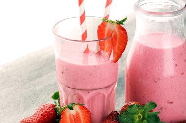 Bir bardak taze çilekli süt, smoothie veya milkshake ve taze çilek. Sulu meyveli sağlıklı yiyecek ve içecek konsepti 