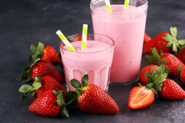 Bir bardak taze çilekli süt, smoothie veya milkshake ve taze çilek. Sulu meyveli sağlıklı yiyecek ve içecek konsepti 
