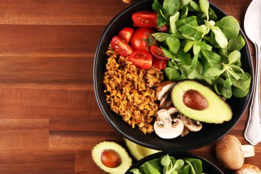 Sağlıklı vejetaryen salata kasesi, kinoa, domates, avokado ve karışık yeşillik, marul. Zencefil ve kinoalı yemek ve sağlık kasesi.