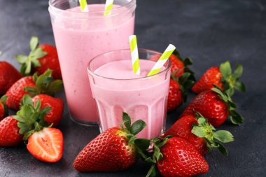 Bir bardak taze çilekli süt, smoothie veya milkshake ve taze çilek. Sulu meyveli sağlıklı yiyecek ve içecek konsepti 