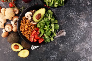 Sağlıklı vejetaryen salata kasesi, kinoa, domates, avokado ve karışık yeşillik, marul. Zencefil ve kinoalı yemek ve sağlık kasesi.