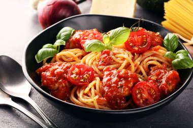 Lezzetli iştah açıcı klasik İtalyan spagettisi domates soslu makarna, peynirli parmesan ve malzemeli fesleğen.