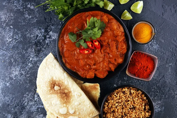 Chicken tikka masala spicy curry meat food in pot with rice and naan bread. indian food with chicken and curry