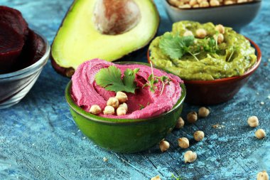 Bir sürü renkli humus, pancar humusu, kırsal arka planda avokado olan humus. Sebze, temiz yemek, diyet, vejetaryen parti yemekleri..