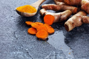 Zerdeçal tozu ve kırsal arka planda taze zerdeçal. Taze organik baharat.