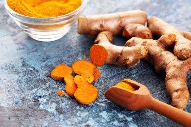 Zerdeçal tozu ve kırsal arka planda taze zerdeçal. Taze organik baharat.